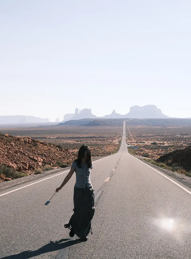 Wenjun walking along the road through Monument Valley