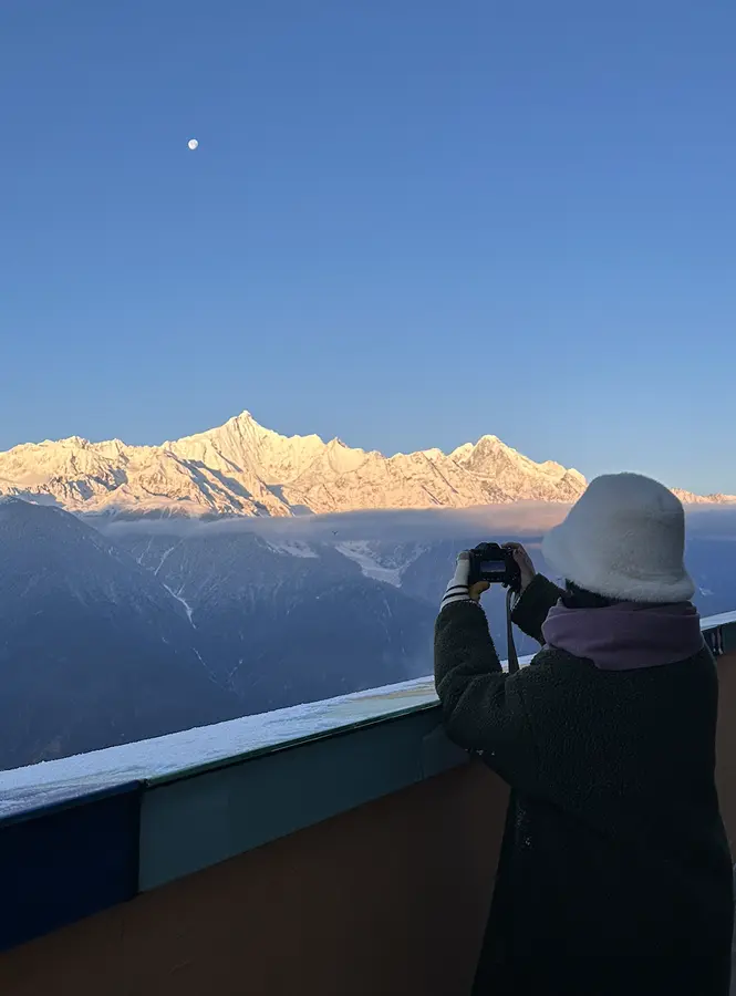 Wenjun photographing sunlit snow mountains